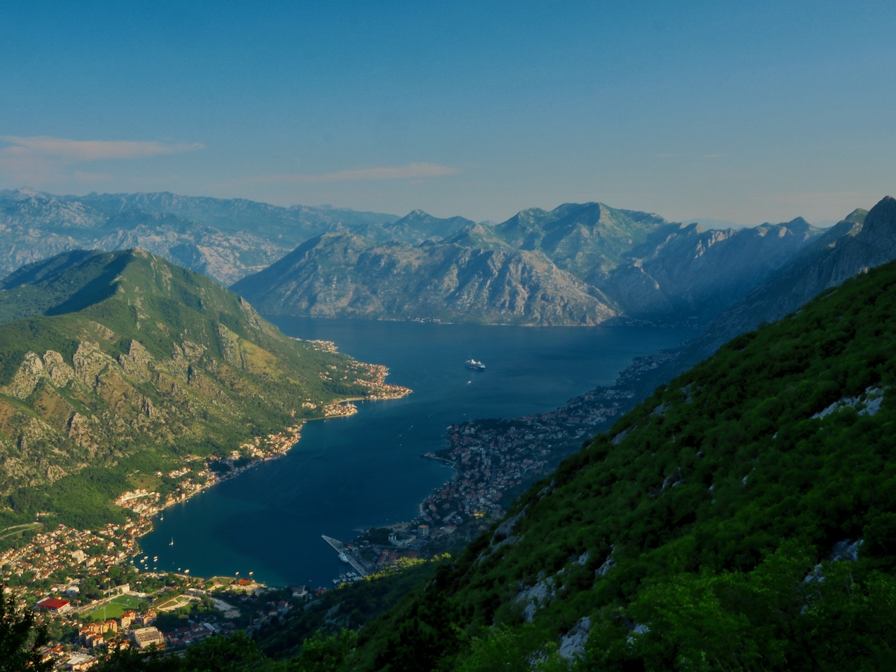 Blick über die Bucht von Kotor mit Bergen, Wasser und Siedlungen am Ufer.
