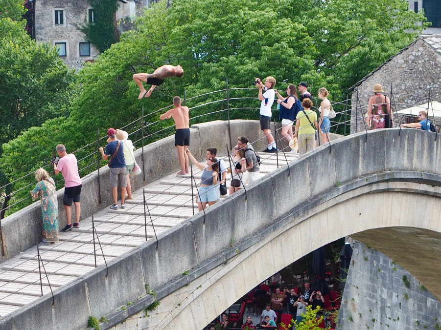 Ein Brückenspringer macht einen Salto von der Stari Most in Mostar.