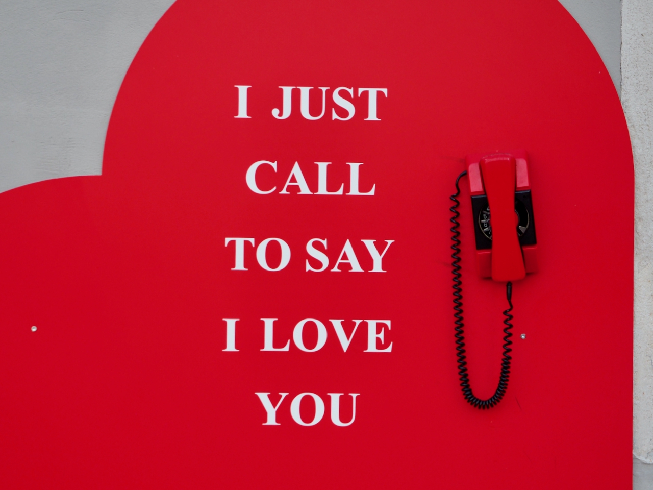 Eine Wand in Pula zeigt ein rotes Herz, ein Telefon und den Schriftzug „I just call to way I love you“.